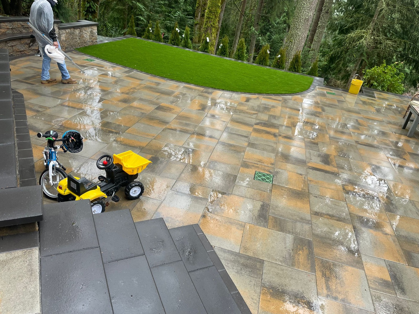 Paver patio angle with green turf and stone boulder border