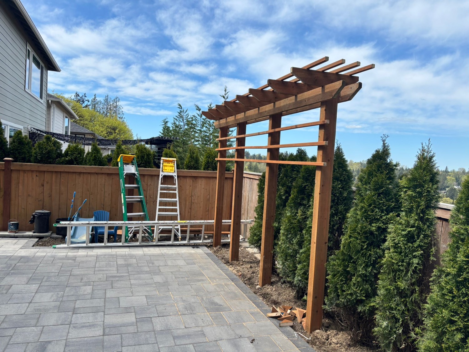 Pergola frame installation above paver patio